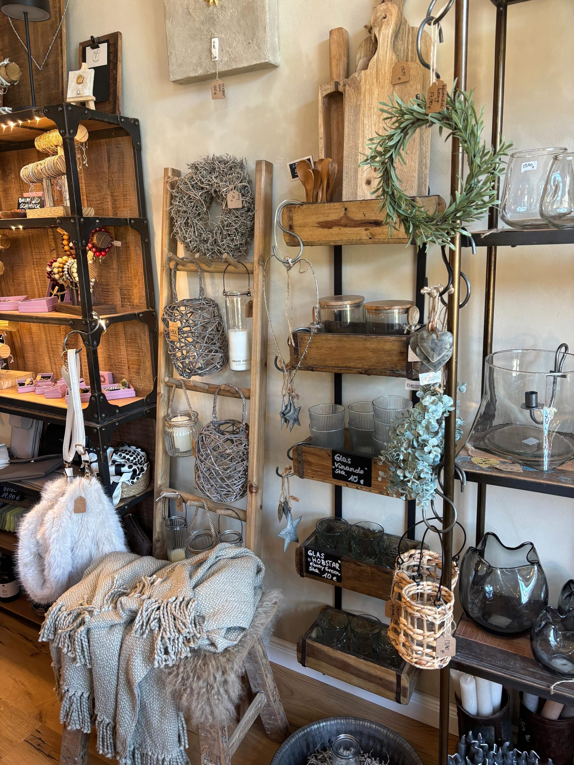 Boho-Leiter mit Kränzen, Stoffen und Sessel mit Fell