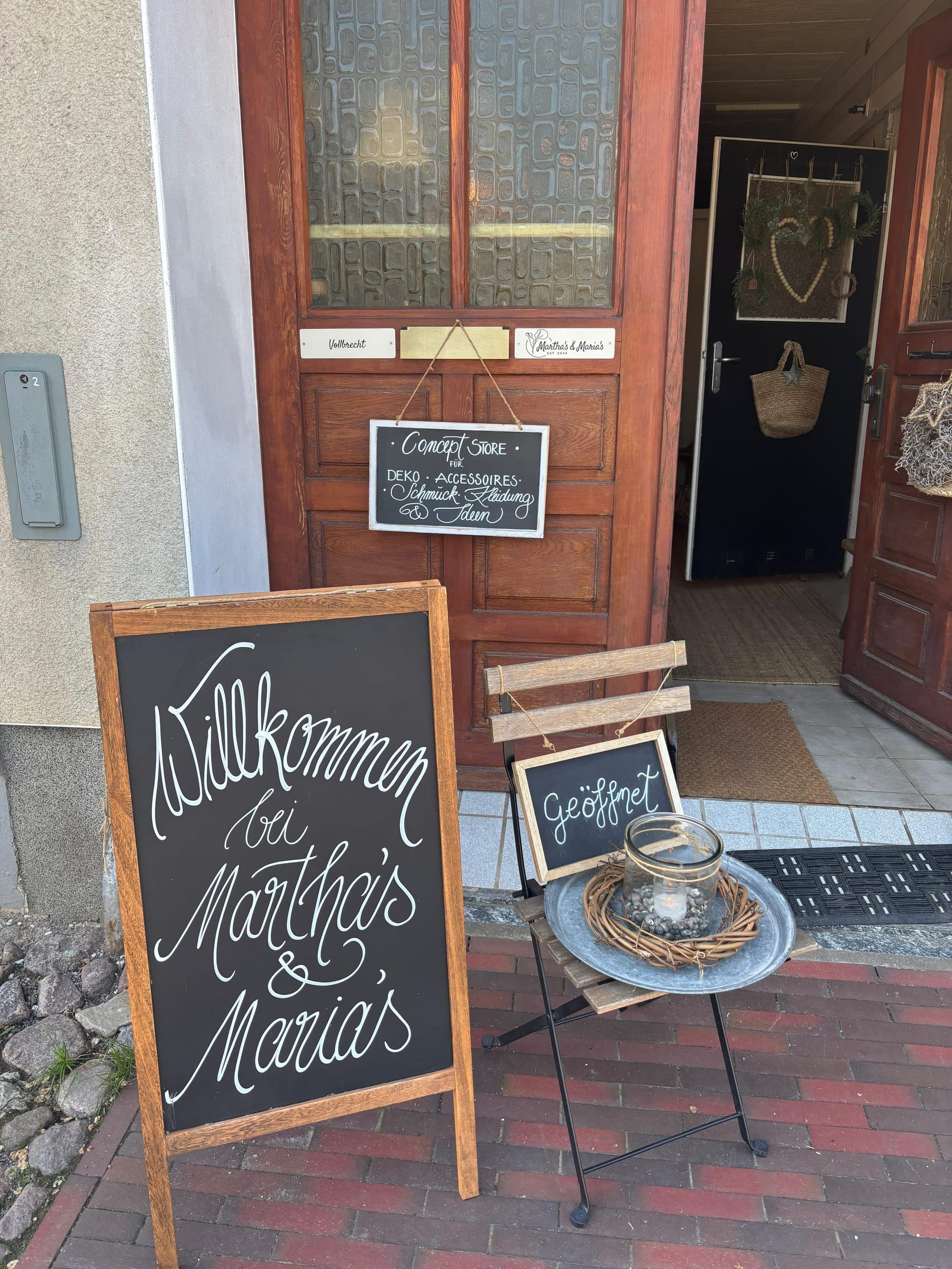 Eingangstür mit Willkommens-Tafel und Geöffnet-Schild